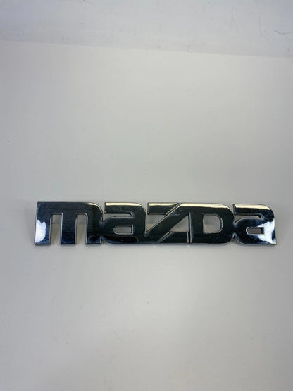 2000-2006 MAZDA MPV REAR TRUNK LID SYMBOL NAMEPLATE BADGE LOGO LC62-51710 OEM