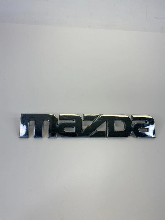 2000-2006 MAZDA MPV REAR TRUNK LID SYMBOL NAMEPLATE BADGE LOGO LC62-51710 OEM